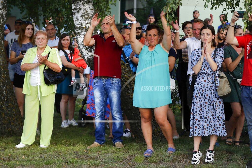 Sergei Grits People applaud police officers as they leave after they attempted to block a rally in support of opposition candidate Sviatlana Tsikhanouskaya ahead of Sunday's election in Soligorsk, Belarus, Tuesday, Aug. 4, 2020. Belarusian police on Tuesday abruptly banned Tsikhanouskaya's previously approved rally in the city of Slutsk, about 100 kilometers (about 60 miles) south of Minsk, under the pretext of road repairs. Officers dispersed several hundred people who had gathered for the rally and detained at least 20 of them, according to Belarusian human rights organization Viasna. (AP Photo/Sergei Grits)