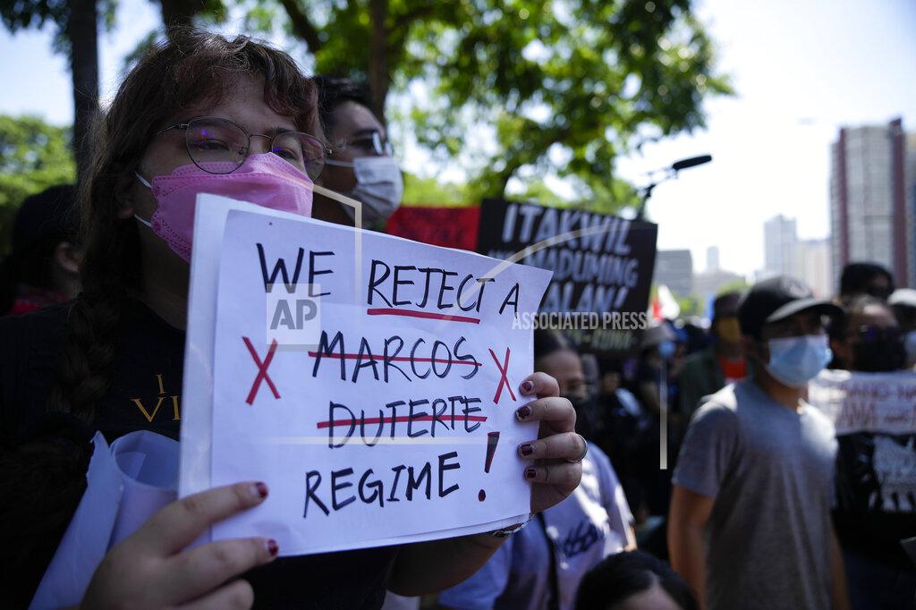 Aaron Favila A protester hold slogans during a rally against presidential frontrunner Ferdinand "Bongbong" Marcos and running mate Sara Duterte, daughter of the current president, during a rally in Pasay, Philippines on Friday, May 13, 2022. Allies of the Philippines' presumptive next president, Ferdinand "Bongbong" Marcos Jr., appear set to strongly dominate both chambers of Congress, further alarming activists after the late dictator's son scored an apparent election victory that will restore his family to the seat of power. (AP Photo/Aaron Favila)