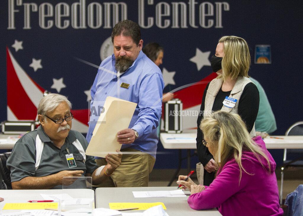 Troy Stolt Catoosa County Board of Elections member Rickey Kittle hands a reviewed ballot to Catoosa County Board of Elections member Phil Langston during the first day of recounts for the 2020 election at the Catoosa County Elections office on Friday, Nov. 13, 2020, in Ringgold, Ga. (Troy Stolt/Chattanooga Times Free Press via AP)