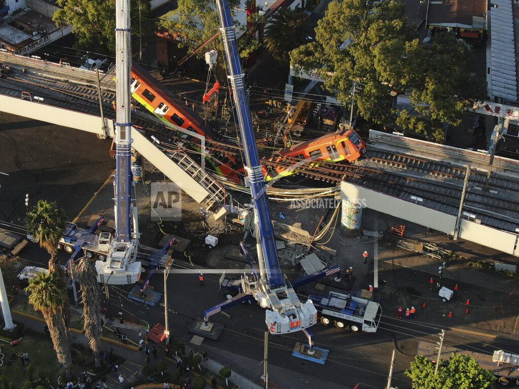 Fernando Llano An aerial view of subway cars dangle at an angle from a collapsed elevated section of the metro, in Mexico City, Tuesday, May 4, 2021. The elevated section of Mexico City's metro collapsed late Monday killing at least 23 people and injuring at least 79, city officials said. (AP Photo/Fernando Llano)