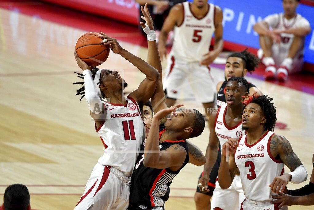 Michael Woods Arkansas guard Jalen Tate (11) tries to drive past Georgia defender Christian Brown (3) during the second half of an NCAA college basketball game Saturday, Jan. 9, 2021, in Fayetteville, Ark. (AP Photo/Michael Woods)