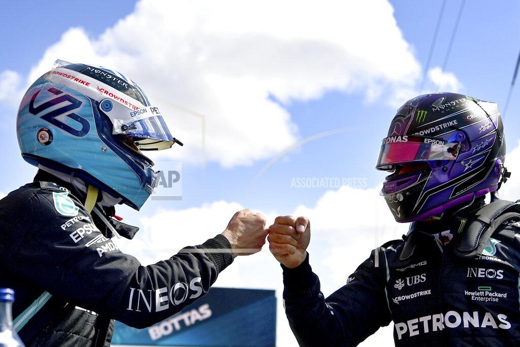 Gabriel Buoys Mercedes driver Lewis Hamilton of Britain, right, congratulates Mercedes driver Valtteri Bottas of Finland after he clocked the fastest time during the qualifying session ahead of the Portugal Formula One Grand Prix at the Algarve International Circuit near Portimao, Portugal, Saturday, May 1, 2021. The Portugal Grand Prix will be held on Sunday. (Gabriel Buoys/Pool via AP)