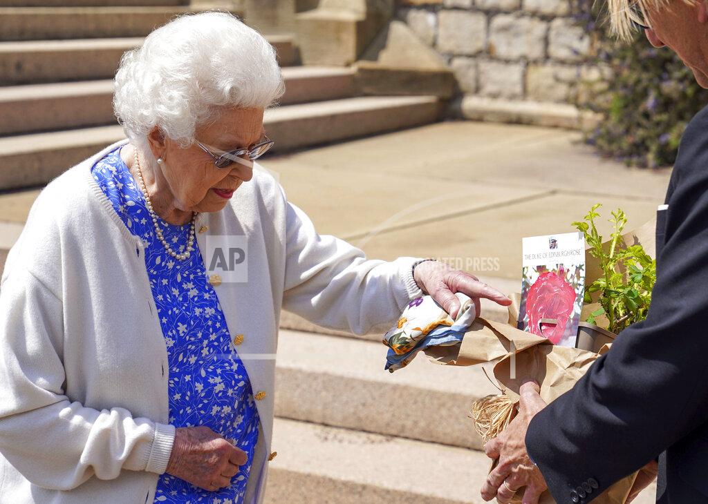 Steve Parsons Britain's Queen Elizabeth II receives a Duke of Edinburgh rose, given to her by Keith Weed, President of the Royal Horticultural Society, at Windsor Castle, England, Wednesday, June 9, 2021. The newly bred deep pink commemorative rose has officially been named in memory of the late Prince Philip Duke of Edinburgh. A royalty from the sale of each rose will go to The Duke of Edinburgh's Award Living Legacy Fund to support young people taking part in the Duke of Edinburgh Award scheme. (Steve Parsons/Pool via AP)