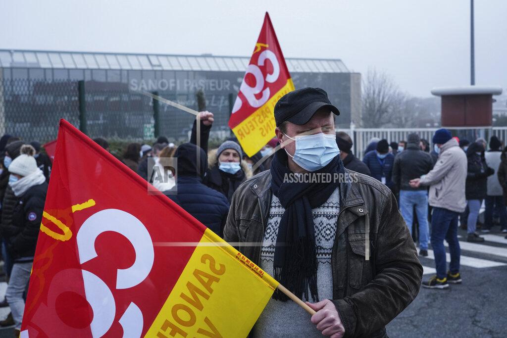 Laurent Cipriani Striking workers gather outside the French pharmaceutical company Sanofi headquarters in Marcy l'Etoile, central France, Tuesday, Jan.19, 2021. Employees of pharmaceutical company Sanofi stage a protest against planned redundancies that they say could slow the fight against the Coronavirus pandemic . Sanofi had been developing Covid vaccines but will not be ready to roll out until late 2021. (AP Photo/Laurent Cipriani)