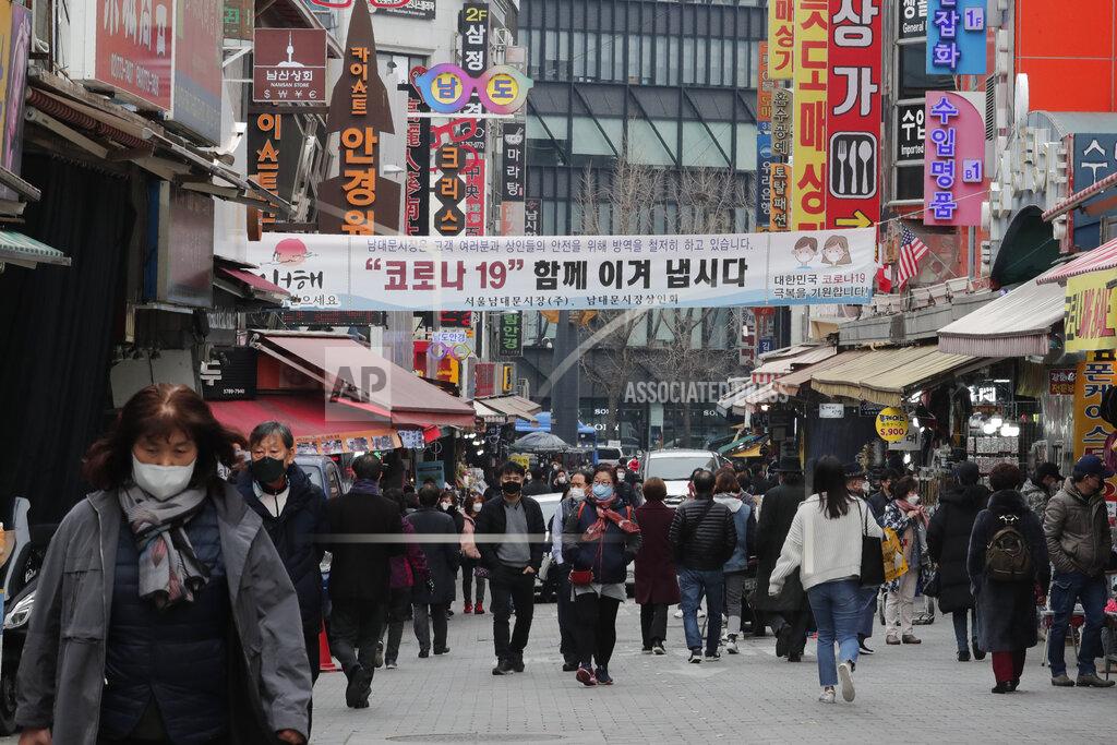 Ahn Young-Joon People wearing face masks walk through a market in Seoul, South Korea, Thursday, March 4, 2021. South Korea's central bank says the country's economy shrank for the first time in 22 years in 2020 as the coronavirus pandemic destroyed service industry jobs and depressed consumer spending. The banner reads: "Lets' overcome Corona 19 together." (AP Photo/Ahn Young-joon)