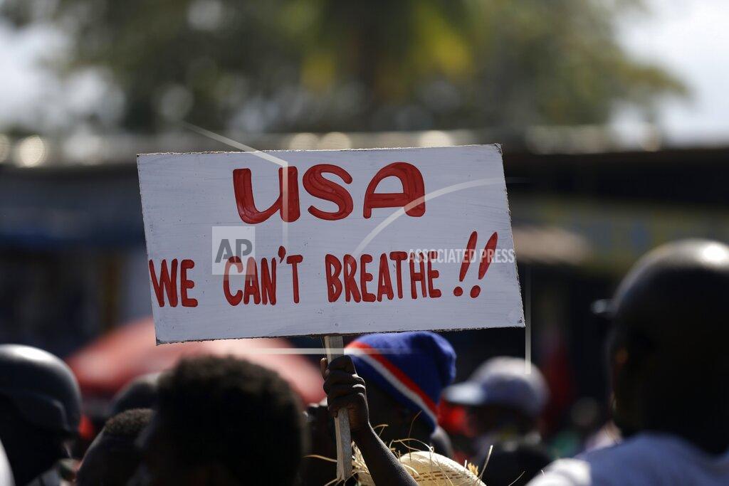 Dieu Nalio Chery A protester holds up a sign during a protest to demand the resignation of Haiti's president Jovenel Moise in Port-au-Prince, Haiti, Wednesday, Jan. 20, 2021. Moise has one more year in power, but a growing groundswell of opposition is organizing protests and demanding he resign next month amid spiraling crime and a crumbling economy. ( AP Photo/ Dieu Nalio Chery)
