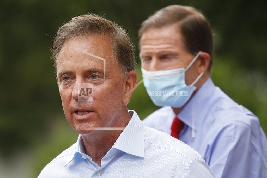 FILE - In this Friday, Aug. 7, 2020 file photo, Connecticut Gov. Ned Lamont speaks to reporters before surveying storm damage in the area in Westport, Conn. Connecticut Gov. Ned Lamont is self-quarantining after his chief spokesperson tested positive for COVID-19, his administration announced late Friday, Nov. 13, 2020. (AP Photo/John Minchillo, File)