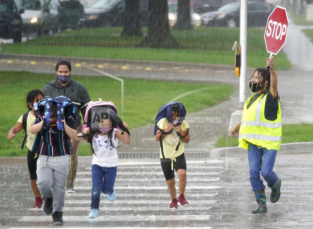 Lm Otero A crossing guard stops traffic for elementary school children to make their way across the street after school let out during a rain storm in Richardson, Texas, Wednesday, Sept. 9, 2020. Many schools across Texas resumed face to face classes this week. (AP Photo/LM Otero)