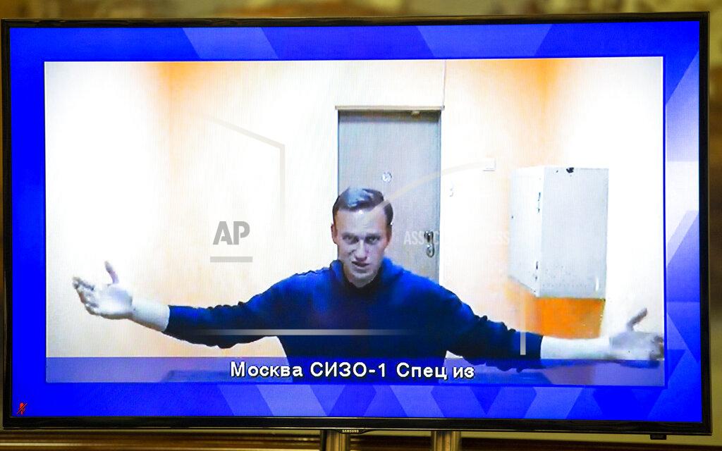 Alexander Zemlianichenko Russian opposition leader Alexei Navalny appears on a TV screen during a live session with the court during a hearing of his appeal in a court in Moscow, Russia, Thursday, Jan. 28, 2021. Navalny was jailed soon after arriving to Moscow after authorities accused him of violating of the terms of his 2014 fraud conviction. A court on Thursday is to hear an appeal on the ruling to remand him into custody. Next week, another court will decide whether to send him to prison for several years for the alleged violations. (AP Photo/Alexander Zemlianichenko)