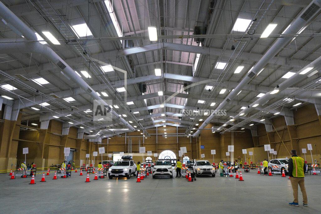 Cars line up as Scripps Health officially opened their new drive-thru vaccination site at Del Mar Fairgrounds on Friday, Feb. 12, 2021, in Del Mar, Calif. (Nelvin C. Cepeda/The San Diego Union-Tribune via AP, Pool)