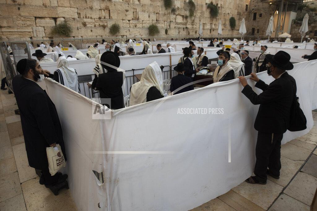 Sebastian Scheiner Ultra-Orthodox Jewish men pray ahead of the Jewish new year at the Western Wall, the holiest site where Jews can pray in Jerusalem's old city, Wednesday, Sept. 16, 2020. A raging coronavirus outbreak is casting a shadow over the normally festive Jewish New Year. With health officials recommending a nationwide lockdown, traditional family gatherings will be muted, synagogue prayers will be limited to small groups and roads will be empty. (AP Photo/Sebastian Scheiner)