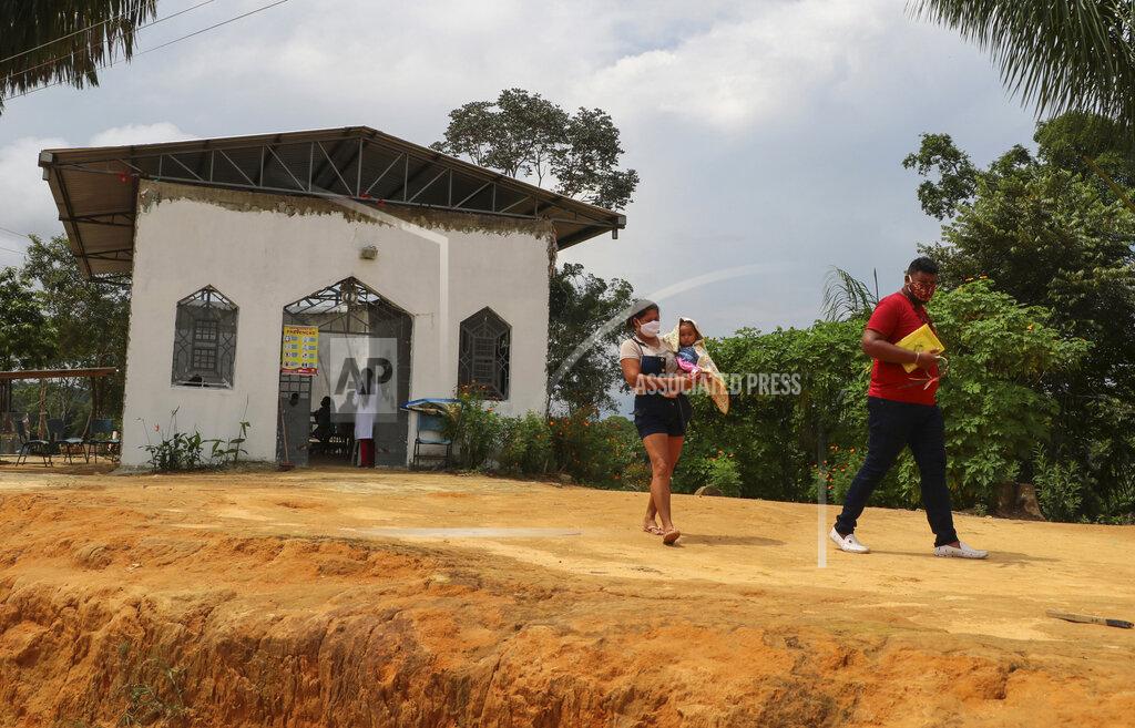 Edmar Barros Icaro de Oliveira and his wife, of the Mura indigenous group, walk home after being tested for COVID-19 at the Indigenous Park, a tribal community in the outskirts of Manaus, Amazonas state, Brazil, Thursday, Jan. 7, 2021. Medical teams are scrambling to assist indigenous people living in outlying areas of Manaus, where medical care is scarce after authorities issued a "State of Emergency" due to rising numbers of infection numbers in Amazonas State. (AP Photo/Edmar Barros)
