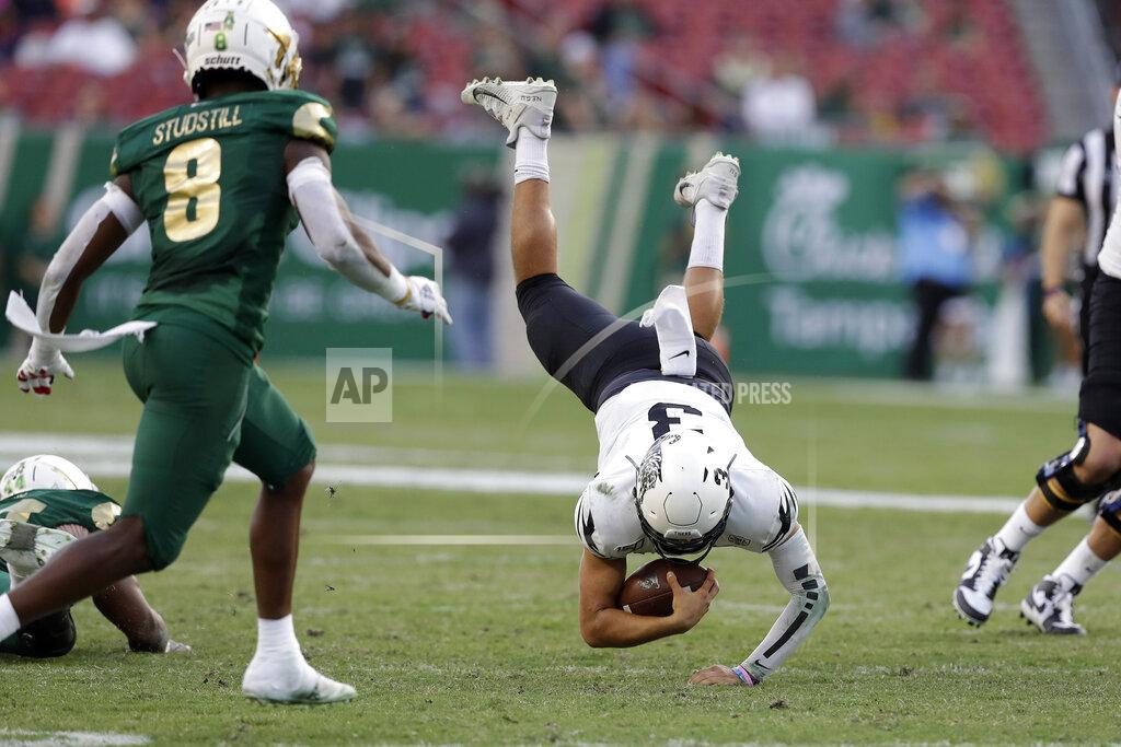 Chris O'meara Memphis quarterback Brady White (3) gets tripped up in front of South Florida defensive back Devin Studstill (8) after a run during the first half of an NCAA college football game Saturday, Nov. 23, 2019, in Tampa, Fla. (AP Photo/Chris O'Meara)