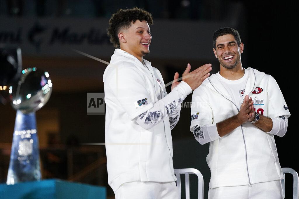 David J. Phillip Kansas City Chiefs' Patrick Mahomes, left, and San Francisco 49ers' Jimmy Garoppolo stand next to the Super Bowl trophy during Opening Night for the NFL Super Bowl 54 football game Monday, Jan. 27, 2020, at Marlins Park in Miami. (AP Photo/David J. Phillip)