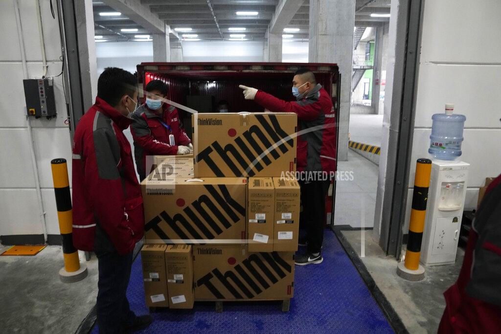 Ng Han Guan Workers load computers onto a delivery truck at the Main Distribution Center built to provide logistic support for the upcoming Beijing Winter Olympics and Paralympics in Beijing, China, Thursday, Dec. 9, 2021. The 34-meter-tall building has started operation at the end of last year to receive, store and distribute furniture, sport and technical equipment, and other materials for the current test events and next year's Winter Games. (AP Photo/Ng Han Guan)