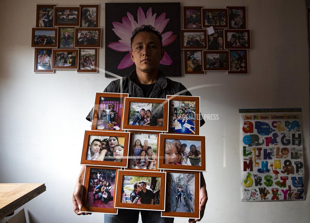 Esteban Felix Jose Collantes holds family photos he printed after his wife died of COVID-19, inside his home where he cares for their five-year-old daughter Kehity, and they live with his sister in Santiago, Chile, Sunday, Sept. 6, 2020. Collantes says he is haunted by questions about why she died and not him when they both caught the virus. (AP Photo/Esteban Felix)