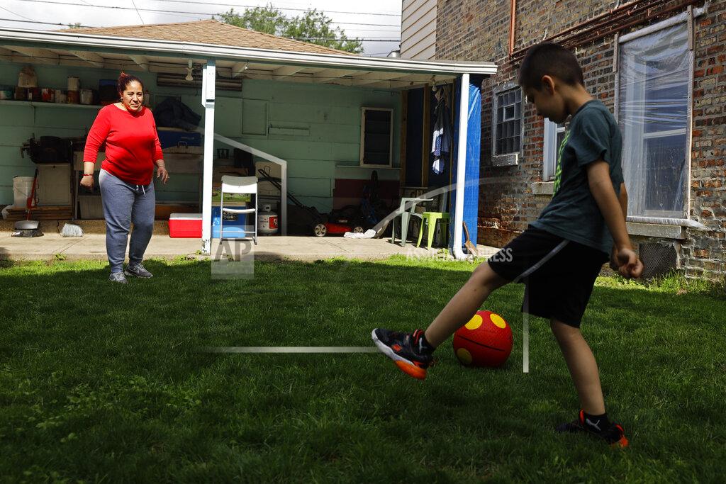 Shafkat Anowar Eugenia Rodriguez, left, plays ball with her youngest son, Aaron, 6, in the backyard of her house Friday, July 2, 2021, in Chicago's Little Village neighborhood. Rodriguez hasn't been eligible for insurance coverage after overstaying a visitor visa from Mexico. She used to wake up every two or three hours at night to check on her mother. Since getting health insurance through the Illinois program, her mother has all the medications she needs. (AP Photo/Shafkat Anowar)