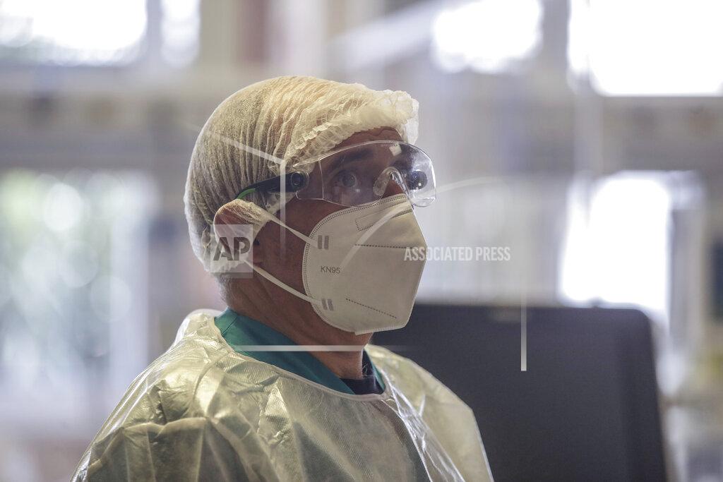 Luca Bruno Doctor Davide Maraggia works in the Intensive Care Unit of Varese’s Circolo Hospital, Italy, Friday, Nov. 6, 2020. During Italy's autumn pandemic resurgence, concern is falling less on intensive care wards and more on regular medical wards, as eight regions have seen the needle move alarmingly into the red-alert zone with more than half of hospital beds dedicated to coronavirus patients. (AP Photo/Luca Bruno)
