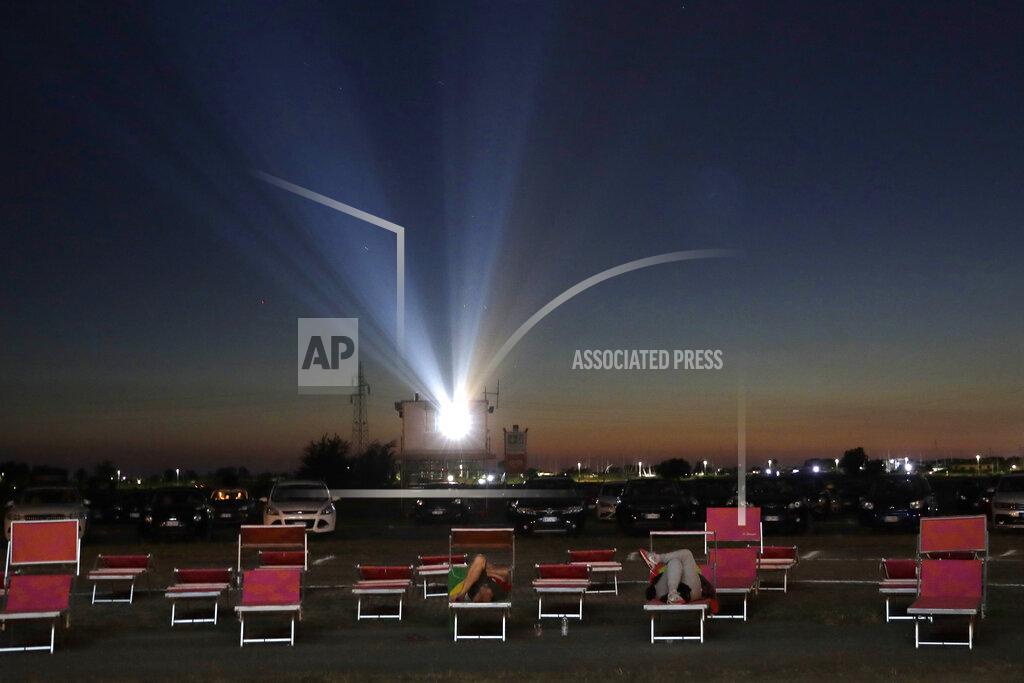 Alessandra Tarantino People in their cars and on lounging chairs watch the movie "Tolo Tolo" at the Paolo Ferrari drive-in cinema in Ostia, on Rome's seaside on Thursday, July 9, 2020. The drive-in cinema that could host up to 460 cars and 50 motorbikes helps in social distancing amid the COVID-19 pandemic. (AP Photo/Alessandra Tarantino)