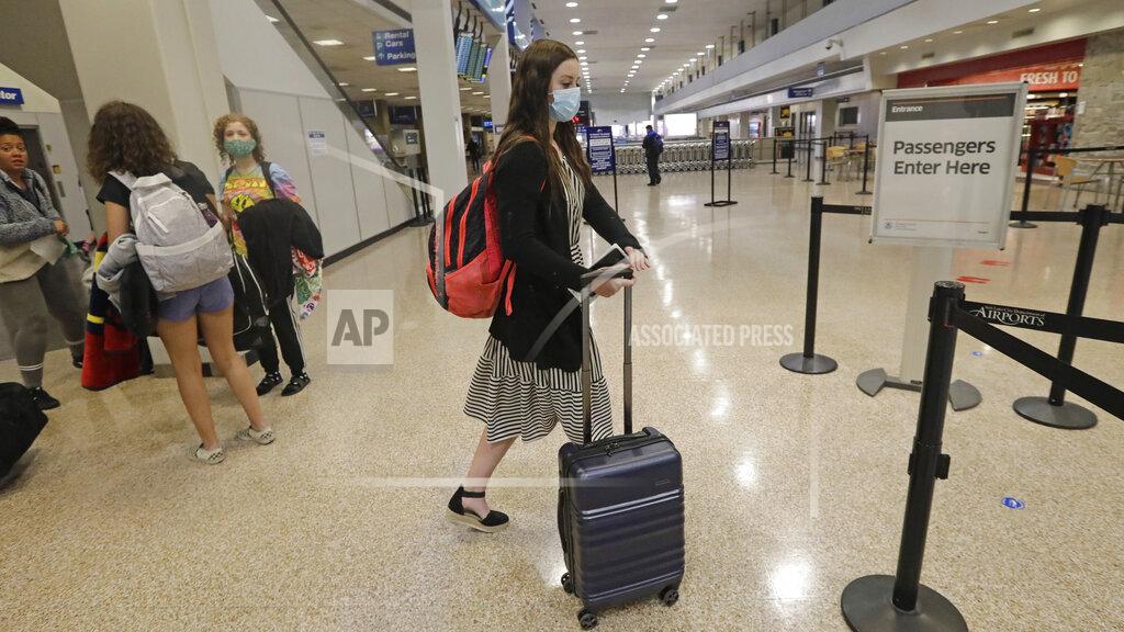 Rick Bowmer In this May 27, 2020, photo, Shaelee Palmer, 20, right, a missionary from The Church of Jesus Christ of Latter-day Saints, walks through Salt Lake City International Airport before leaving on her mission to North Carolina. After hastily bringing home 26,000 young men and women who were serving in foreign countries, the faith has begun sending many of them out again in their home countries with a new focus on online work that could stick even when the pandemic is over, church officials told The Associated Press. (AP Photo/Rick Bowmer)