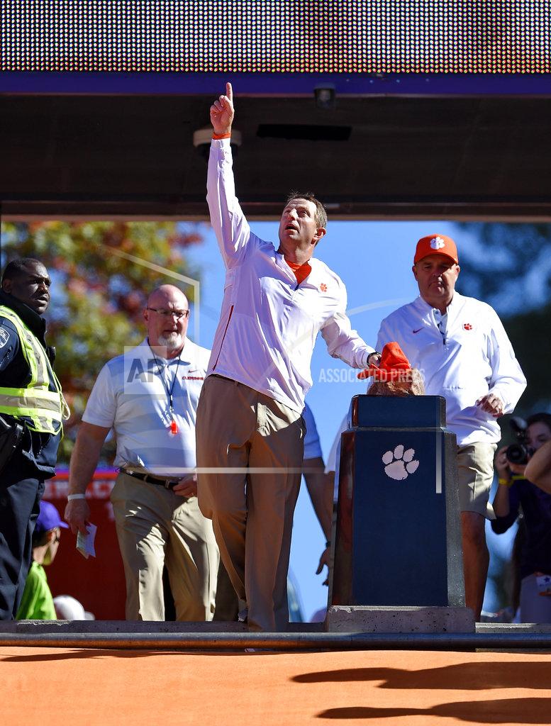 Richard Shiro Clemson head coach Dabo Swinney points to the sky after touching Howard's rock before the start of an NCAA college football game against Louisville, Saturday, Nov. 3, 2018, in Clemson, S.C. The rock is the center of a longstanding tradition where players touch it before running down the hill in the east end zone at each home football game. (AP Photo/Richard Shiro)