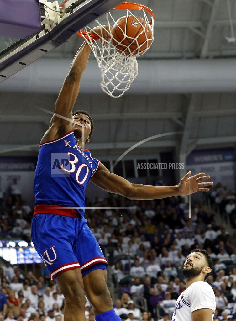 Tony Gutierrez Kansas guard Ochai Agbaji (30) dunks the ball over TCU's Alex Robinson, bottom right, in the first half of an NCAA college basketball game in Fort Worth, Texas, Monday, Feb. 11, 2019. (AP Photo/Tony Gutierrez)