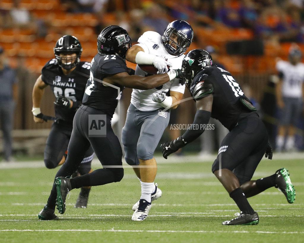 Marco Garcia Nevada running back Toa Taua (35) gets pulled down by Hawaii defensive back Ikem Okeke (22) and linebacker Paul Scott (15) during the second quarter of an NCAA college football game, Saturday, Oct. 20, 2018, in Honolulu. (AP Photo/Marco Garcia)