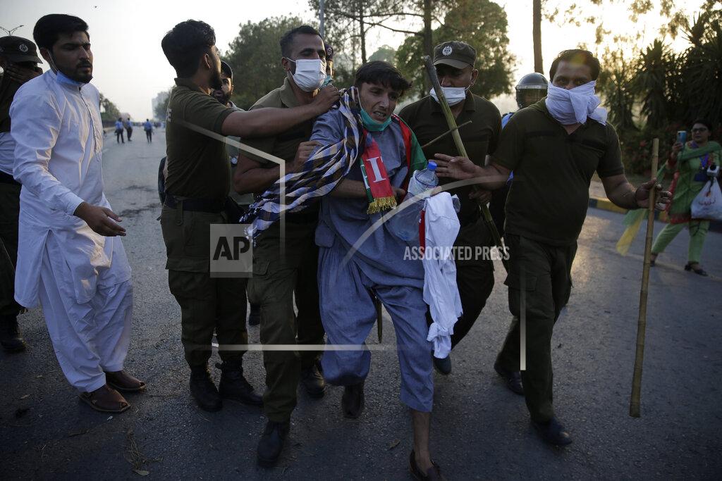 Rahmat Gul Police detain a supporter of Pakistan's key opposition during a protest march in Islamabad, Pakistan, Wednesday, May 25, 2022. Pakistani authorities blocked off all major roads into the capital Islamabad on Wednesday, after a defiant former Prime Minister Imran Khan said he would march with demonstrators to the city center for a rally he hopes will bring down the government and force early elections. (AP Photo/Rahmat Gul)