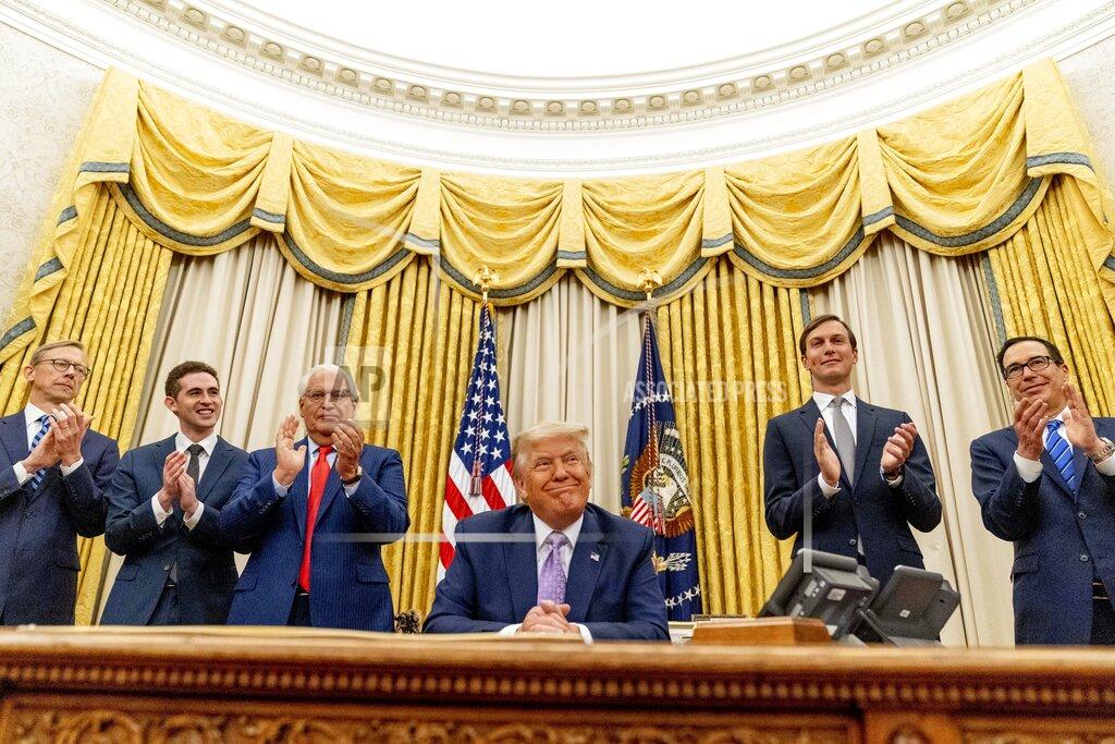 Andrew Harnik President Donald Trump, accompanied by From left, U.S. special envoy for Iran Brian Hook, Avraham Berkowitz, Assistant to the President and Special Representative for International Negotiations, U.S. Ambassador to Israel David Friedman, President Donald Trump's White House senior adviser Jared Kushner, and Treasury Secretary Steven Mnuchin, smiles in the Oval Office at the White House, Wednesday, Aug. 12, 2020, in Washington. Trump said on Thursday that the United Arab Emirates and Israel have agreed to establish full diplomatic ties as part of a deal to halt the annexation of occupied land sought by the Palestinians for their future state. (AP Photo/Andrew Harnik)
