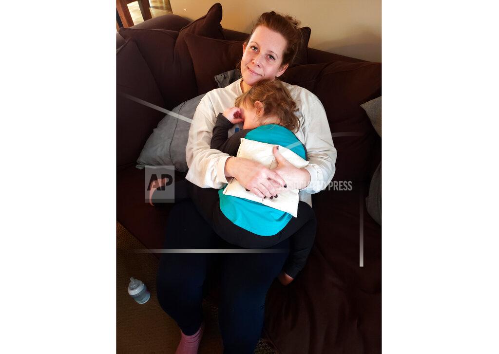 This image shows released by Tracy Wakeford shows Wakeford and her daughter Emilia, 2, at their home in Rockport, Maine. As the world has changed in overwhelming ways since the coronavirus era took hold, the complicated ripple effects have been well documented in terms of family life but less so with friendships. Wakeford finds it frustrating to see single friends or friends without kids posting online about entertainment options being limited. She is without daycare and admits to “snoozing” friends on Facebook whose posts sound like they're on a mini-vacation. (Randall Wakeford via AP)