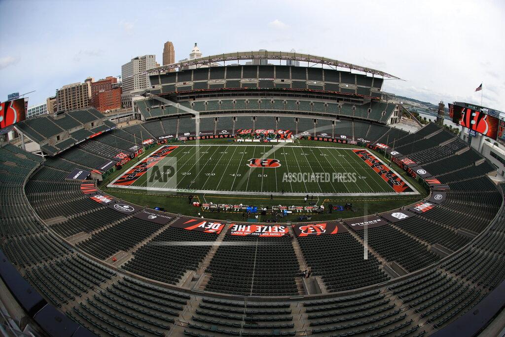 Aaron Doster FILE—In this file photo from Sept. 13, 2020, players walk out to the field before at Paul Brown stadium that is devoid of fans to start warming up before an NFL football game between the Cincinnati Bengals and the Los Angeles Chargers, in Cincinnati. About one in six Ohio school districts asked the state for permission to add additional spectators for fall sporting events, exceeding the limits set by Gov. Mike DeWine in last month's sports order, records show. (AP Photo/Aaron Doster)