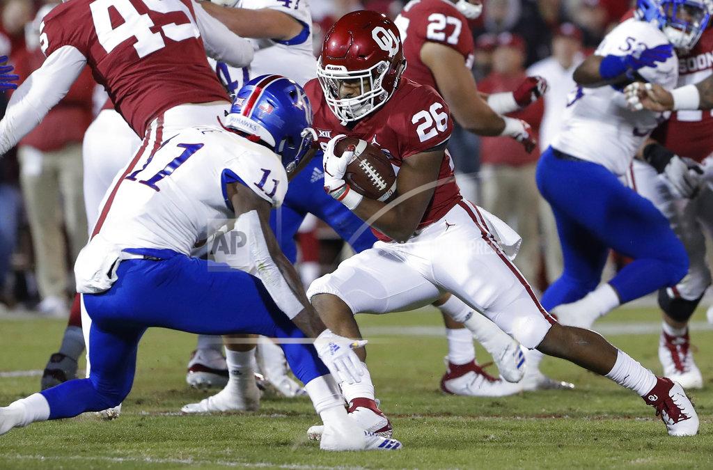 Alonzo Adams Oklahoma running back Kennedy Brooks (26) runs as Kansas safety Mike Lee (11) defends during the first half of an NCAA college football game in Norman, Okla., Saturday, Nov. 17, 2018. (AP Photo/Alonzo Adams)