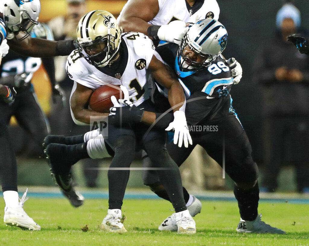 Jason E. Miczek FILE - In this Dec. 17, 2018, file photo, New Orleans Saints' Alvin Kamara (41) is tackled by Carolina Panthers' Kawann Short (99) in the first half of an NFL football game in Charlotte, N.C. Panthers two-time Pro Bowler Short thought about opting out of the NFL season, but the 6-foot-3, 315-pound defensive tackle simply could not bear the thought of missing another football season. (AP Photo/Jason E. Miczek, File)