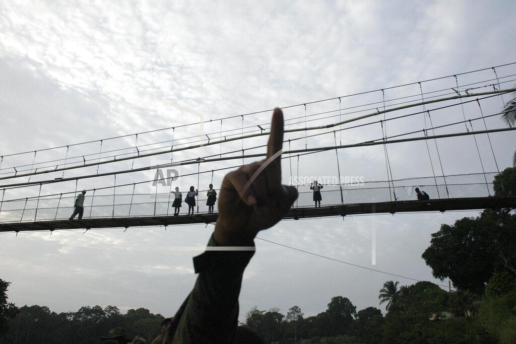 FILE - In this June 19, 2018 file photo, a Panama border police officer points as he begins to patrol in the Darien Province, on the border with Colombia, in Yaviza, Panama. As Panama deals with the care of migrants living in shelters in the jungle province of Darien in May 2020, the Inter-American court ordered Panama to take urgent measures to protect migrants' lives in the midst of the coronavirus pandemic. (AP Photo/Arnulfo Franco, File)