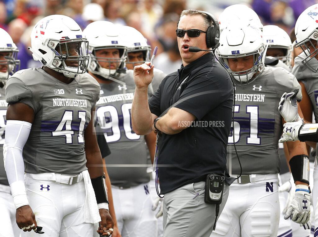 FILE - In this Saturday, Sept. 8, 2018, file photo, Northwestern coach Pat Fitzgerald speaks with his team during a break in the play in an NCAA college football game against Duke, in Evanston, Ill. On the latest AP Top 25 College Football Podcast, Fitzgerald plays it coy with the Wildcats’ quarterback competition. He is not ready to hand the job to Hunter Johnson, but the transfer from Clemson could be one of the most-pivotal players in the country. (AP Photo/Jim Young, File)