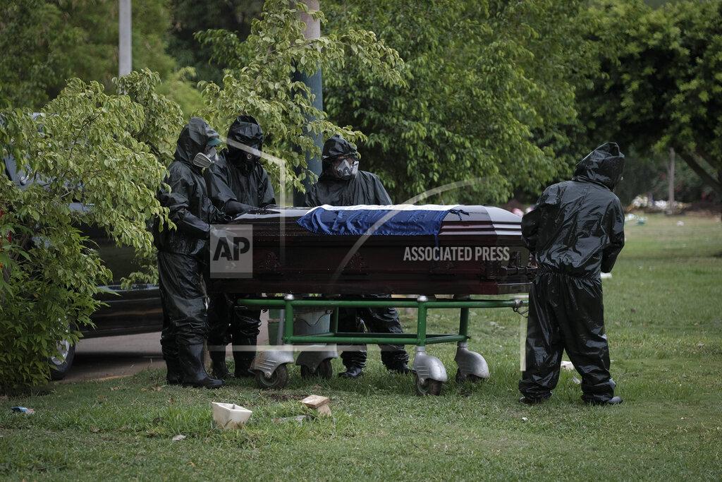 Alfredo Zuniga Workers in full protection gear against the spread of the new coronavirus move the coffin with the body of journalist Carlos Bermudez for burial at the Jardines del Recuerdo cemetery in Managua, Nicaragua, Wednesday, May 27, 2020. Family members said that Bermudez died from COVID-19, even as President Daniel Ortega's government has gone from denying the disease's presence in the country to actively trying to conceal its spread. (AP Photo/Alfredo Zuniga)