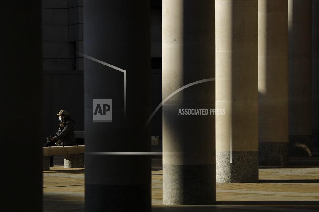 Matt Dunham A woman wearing a face mask to curb the spread of coronavirus sits in the sun in Paternoster Square, in the City of London financial district of London, Friday, Jan. 22, 2021, during England's third national lockdown since the coronavirus outbreak began. Nearly a year to the day after Wuhan went into lockdown to contain a virus that had already escaped, President Joe Biden began putting into effect a new war plan for fighting the outbreak in the United States, Germany topped 50,000 deaths, and Britain closed in on 100,000. (AP Photo/Matt Dunham)