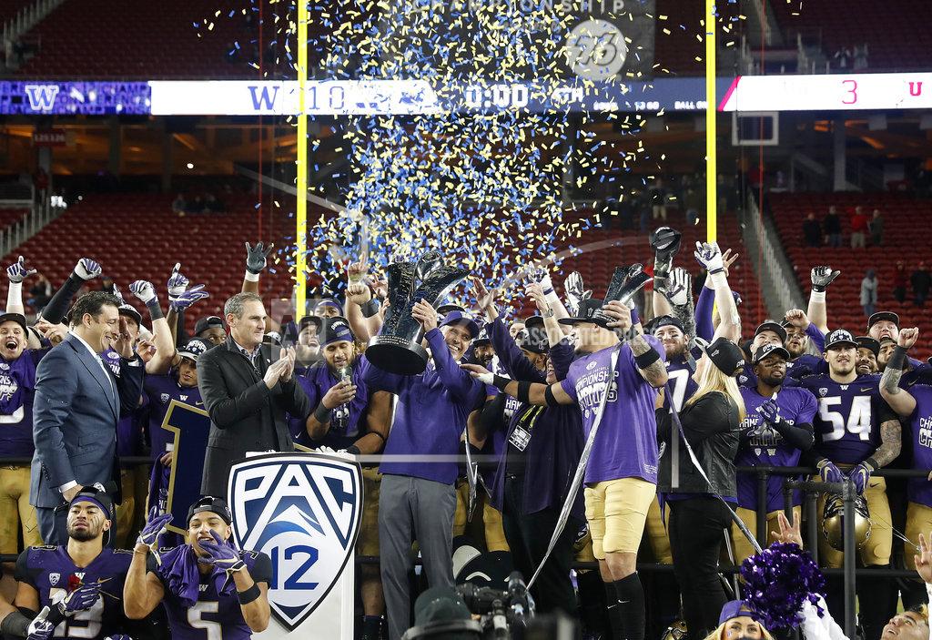 Tony Avelar Washington coach Chris Petersen, center, raises the trophy as he celebrates with his players after a 10-3 win over Utah in the Pac-12 Conference championship NCAA college football game in Santa Clara, Calif., Friday, Nov. 30, 2018. (AP Photo/Tony Avelar)