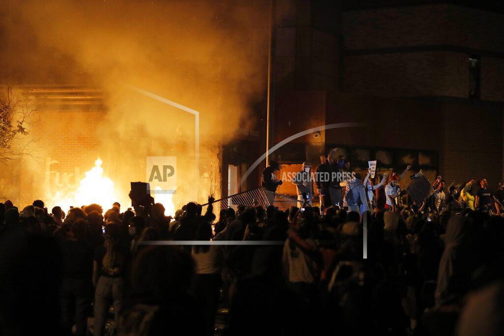 Julio Cortez Protesters gather in front of the burning Minneapolis police 3rd Precinct building Thursday, May 28, 2020, in Minneapolis. Protests over the death of George Floyd, a black man who died in police custody Monday, broke out in Minneapolis for a third straight night. (AP Photo/Julio Cortez)