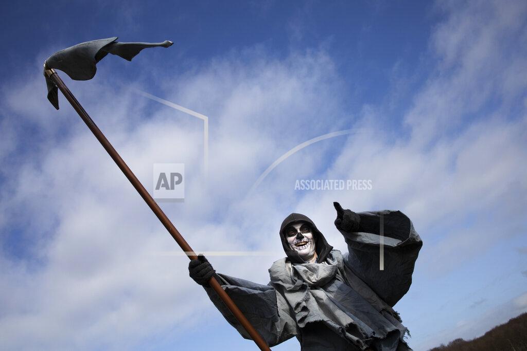 Peter Dejong A man dressed as the grim reaper tales apart in a demonstration, ahead of three days of voting starting Monday in a general election, to protest government policies including the curfew, lockdown and coronavirus related restrictions in The Hague, Netherlands, Sunday, March 14, 2021. (AP Photo/Peter Dejong)