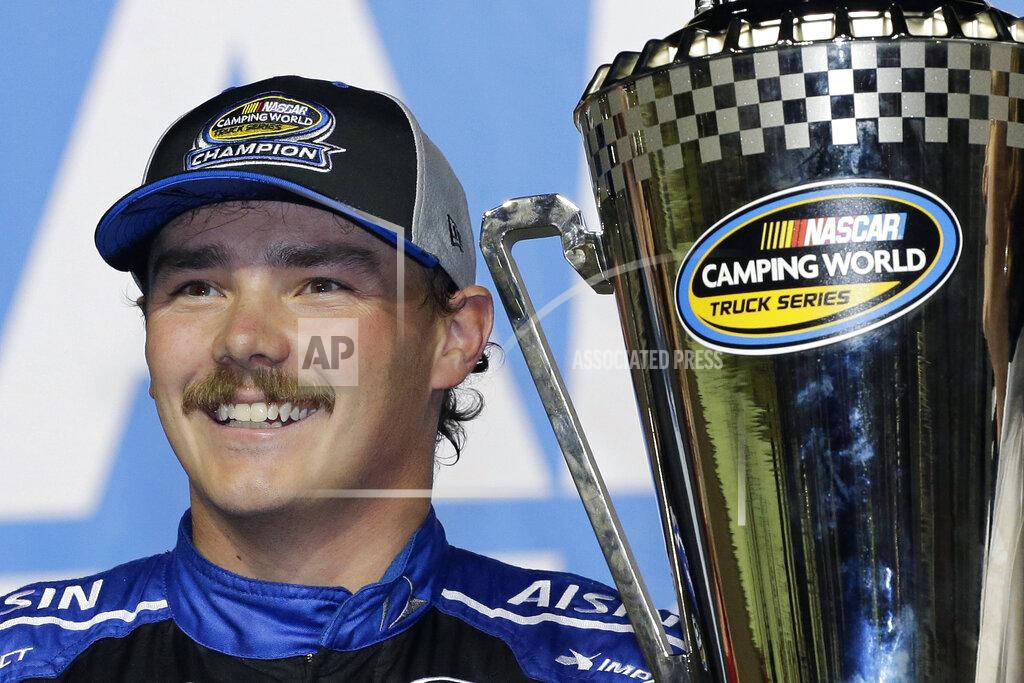 Terry Renna FILE - In this Nov. 16, 2018, file photo, Brett Moffitt stands with his trophy in Victory Lane after winning the NASCAR Truck Series auto racing season championship, at Homestead-Miami Speedway in Homestead, Fla. Brett Moffitt, Ross Chastain, Austin Hill, Johnny Sauter, Stewart Friesen, Tyler Ankrun, Grant Enfinger and Matt Crafton are competing in the NASCAR Truck Series playoffs.(AP Photo/Terry Renna, File)