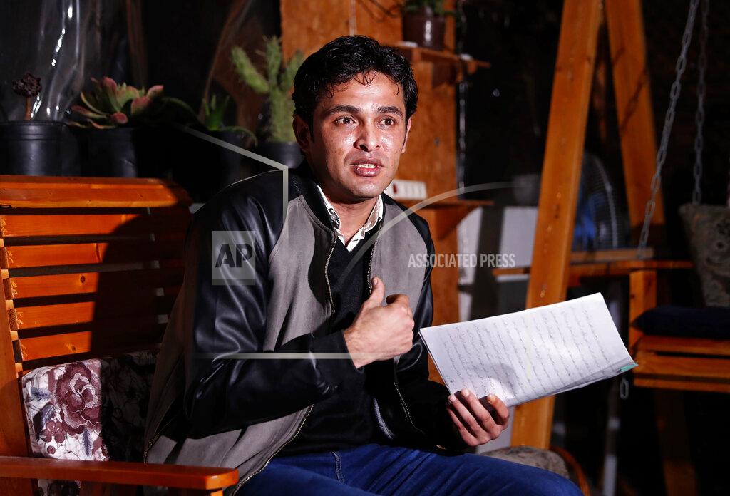 Adel Hana Rami Aman, a Palestinian Gazan peace activist, holds note's in which he recalled his ordeal, during an interview on the roof of his family house in Gaza City, Feb. 10, 2021. After months of torture and interrogations in a Hamas prison, Aman says he was offered an unconventional proposition: Divorce your wife and you are free to go. Aman had recently signed a marriage contract with the daughter of a Hamas official, and the ruling Islamic militant group apparently wanted to dispel any insinuation that it supported Aman’s outreach to Israeli peace activists. (AP Photo/Adel Hana)