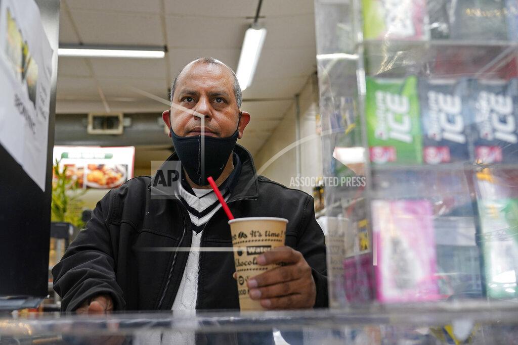 Kathy Willens Bodega owner Francisco Marte pauses behind the counter in his store, Wednesday, Feb. 10, 2021, in the Bronx borough of New York. Marte, president of the Bodega and Small Business Group, which represents bodegas in New York, said he's been lobbying local officials to set aside COVID-19 vaccine appointments for bodega workers, many of whom are unaware they are eligible. He hopes the recent opening of a large vaccination site at Yankee stadium will make access easier. (AP Photo/Kathy Willens)