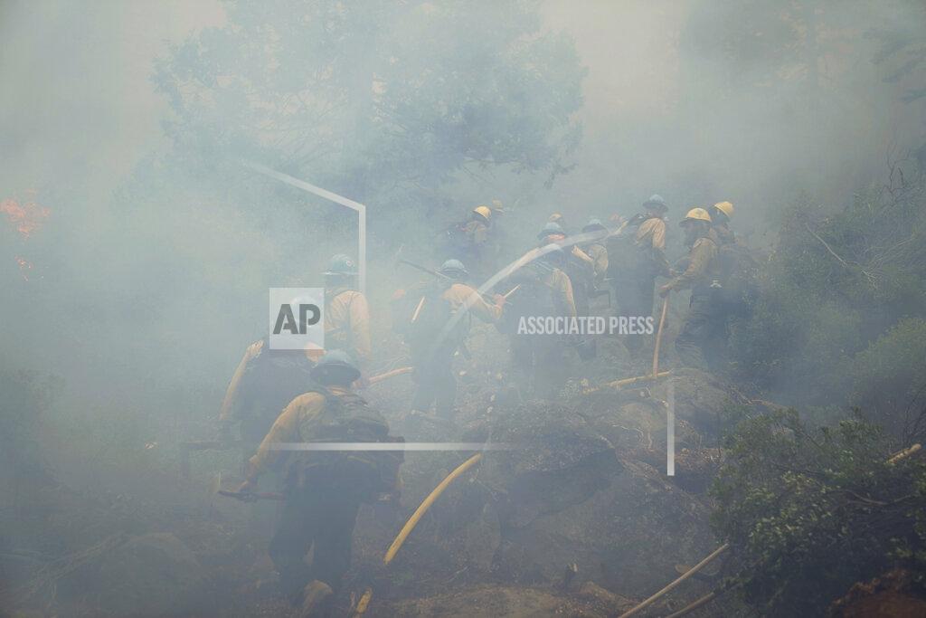 Jae C. Hong Members of a hotshot crew walk through thick smoke from the Caldor Fire in South Lake Tahoe, Calif., Friday, Sept. 3, 2021. Fire crews took advantage of decreasing winds to battle a California wildfire near popular Lake Tahoe and were even able to allow some people back to their homes but dry weather and a weekend warming trend meant the battle was far from over. (AP Photo/Jae C. Hong)
