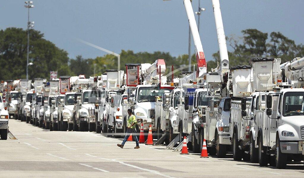 Stephen M. Dowell Dozens of utility trucks are lined up to be processed by Florida Power & Light at Daytona International Speedway on Saturday, Aug. 1, 2020. Thousands of electric lineman crews and other employees were processed at the site to be sent to staging centers in preparation for Hurricane Isaias. Isaias snapped trees and knocked out power as it blew through the Bahamas on Saturday and weakened to a tropical storm as it churned toward the Florida coast, where it still threatened to complicate efforts to contain the coronavirus in a hot spot. (Stephen M. Dowell/Orlando Sentinel via AP)