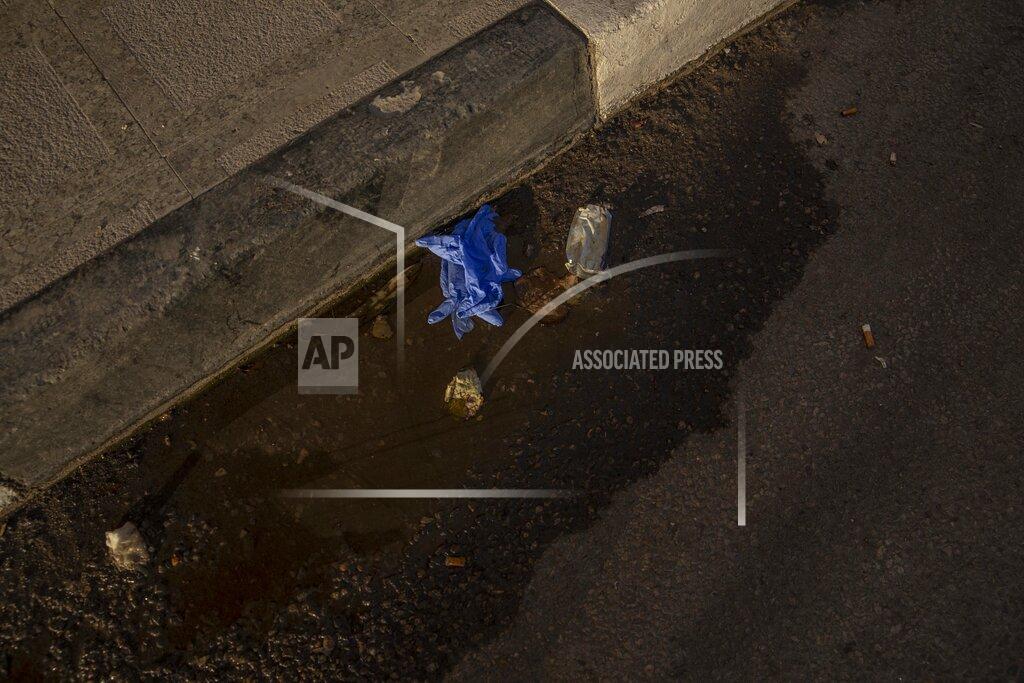 Nariman El-Mofty FILE - This April 3, 2020 file photo, shows used medical gloves thrown on a street in Cairo, Egypt. Coronavirus infections are surging in the country of 100 million, threatening to overwhelm hospitals. (AP Photo/Nariman El-Mofty, File)