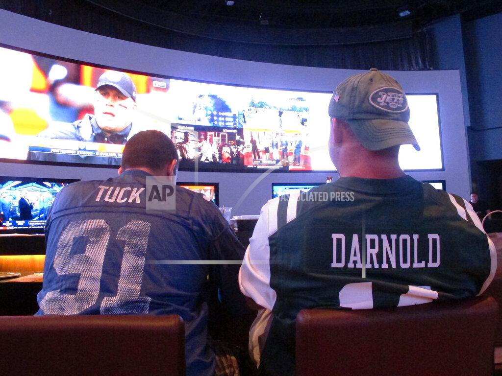 Wayne Parry This Sept. 9, 2018 photo shows fans of the New York Giants and Jets watching a football game after placing bets in the sports betting lounge at the Ocean Casino Resort in Atlantic City, N.J. The coronavirus outbreak has added new wrinkles for bettors this year, but even so, the nation's sports books expect a record year of bets on football in 2020 from an antsy public that has been cooped up for months amid the pandemic. (AP Photo/Wayne Parry)