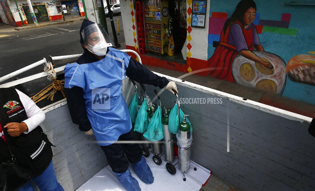 Marco Ugarte City worker Alexis Hernandez rides in the back of a cargo truck transporting tanks of oxygen for COVID-19 patients, in the Iztapalapa borough of Mexico City, Friday, Jan. 15, 2021. The city offers free oxygen refills for COVID-19 patients. (AP Photo/Marco Ugarte)
