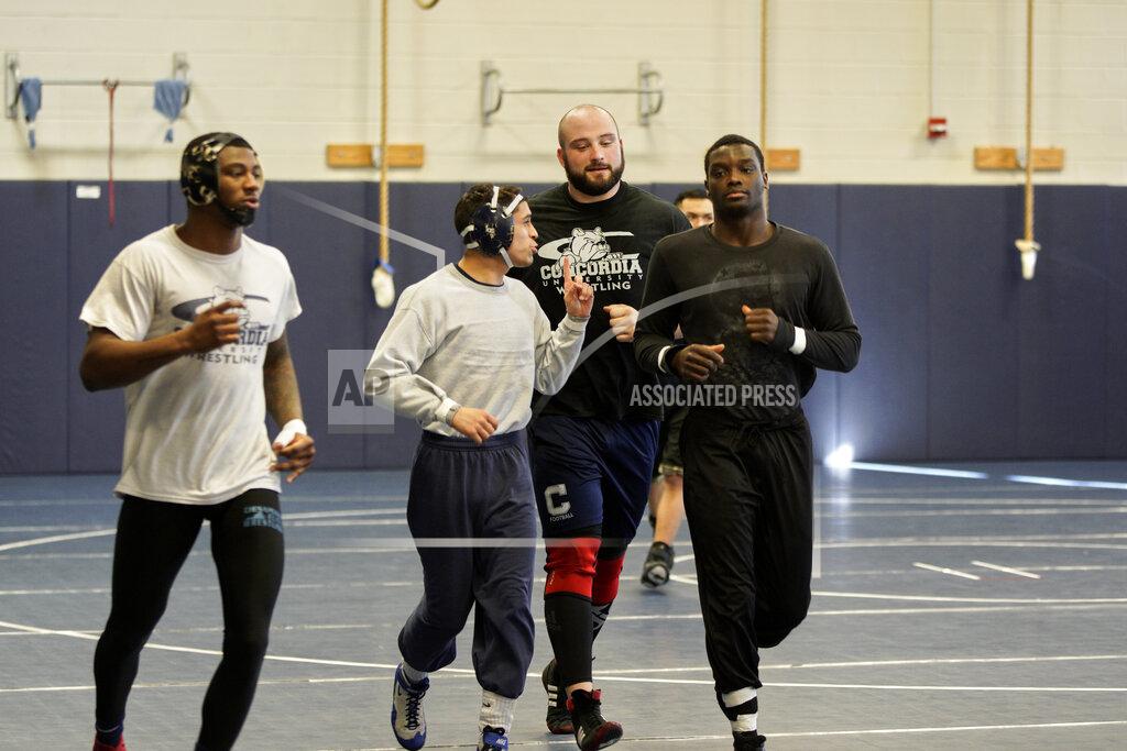 Nati Harnik In this March 2, 2020, photo, former Nebraska football player Tanner Farmer and current wrestler for Concordia University, second from right, jogs with teammates during practice in Seward, Neb. A year ago Farmer was thought to be on the rise as an NFL draft prospect. He had started three years on Nebraska's offensive line and turned in a stellar performance at the Cornhuskers' pro day. It turned out he went undrafted, so he took a volunteer assistant's job with the Concordia football team and then, quite by accident, discovered he had one semester of eligibility to compete in another sport in the National Association of Intercollegiate Athletics. He chose wrestling. (AP Photo/Nati Harnik)