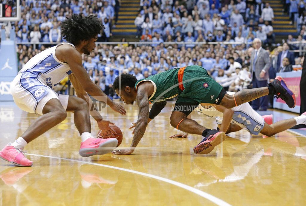 Gerry Broome North Carolina's Coby White, left, and Miami's Chris Lykes chase a loose ball during overtime in an NCAA college basketball game in Chapel Hill, N.C., Saturday, Feb. 9, 2019. North Carolina won 88-85. (AP Photo/Gerry Broome)